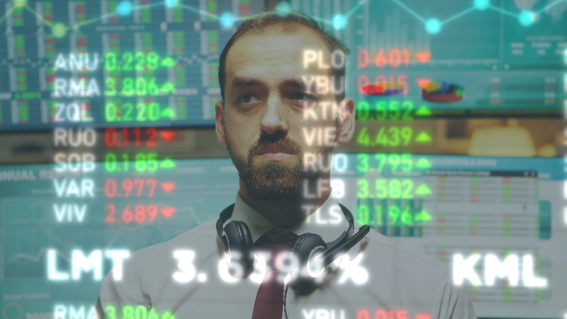 Un analista financiero con barba y auriculares alrededor del cuello observa fijamente datos bursátiles e indicadores bursátiles holográficos superpuestos en pantalla.